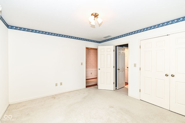 unfurnished bedroom with a closet, baseboards, visible vents, and carpet floors