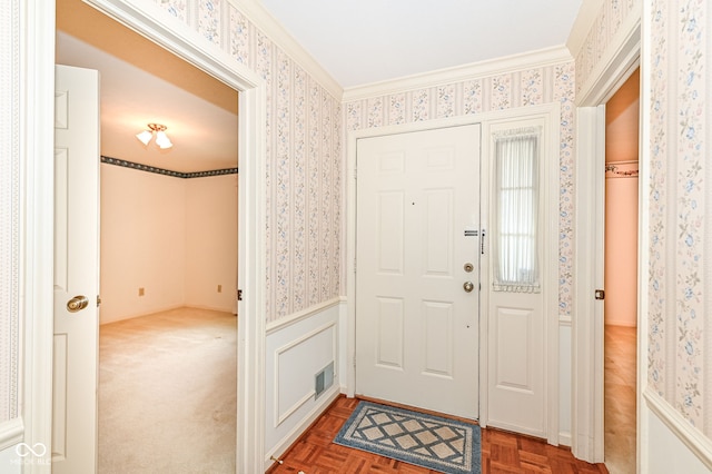 foyer entrance featuring visible vents, wainscoting, and wallpapered walls