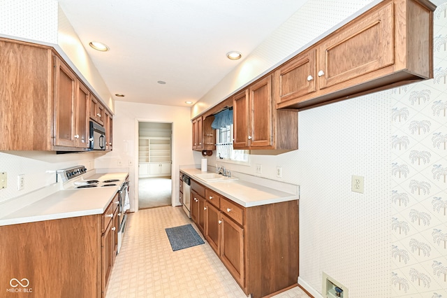 kitchen with white electric range, a sink, brown cabinetry, black microwave, and dishwasher