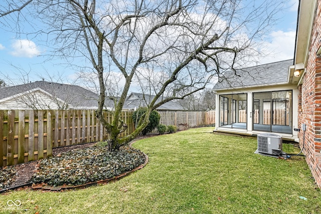 view of yard featuring central AC unit, a fenced backyard, and a sunroom