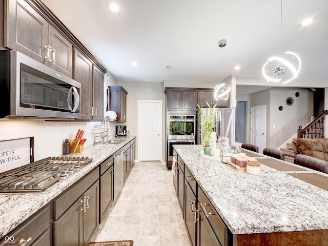 kitchen featuring tasteful backsplash, dark brown cabinets, appliances with stainless steel finishes, and a center island