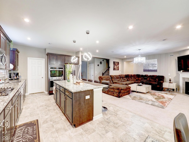 kitchen with recessed lighting, a tile fireplace, stainless steel appliances, open floor plan, and a center island