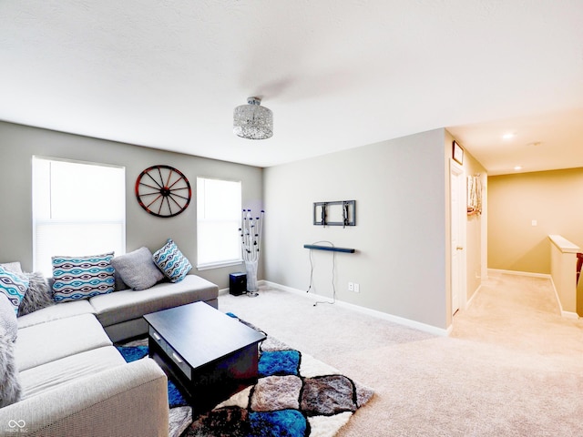 living area with light colored carpet and baseboards