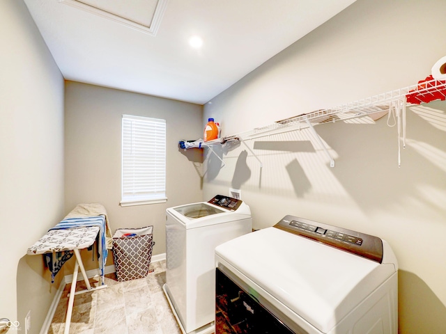 laundry room with laundry area, independent washer and dryer, attic access, and baseboards