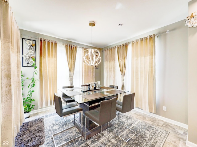 dining space with baseboards and a chandelier