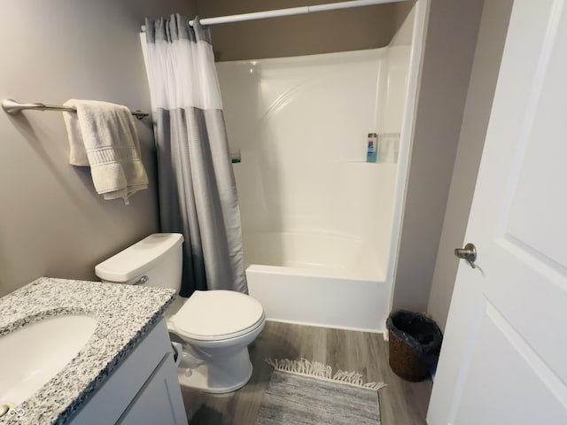 full bathroom featuring vanity, toilet, wood finished floors, and shower / tub combo with curtain