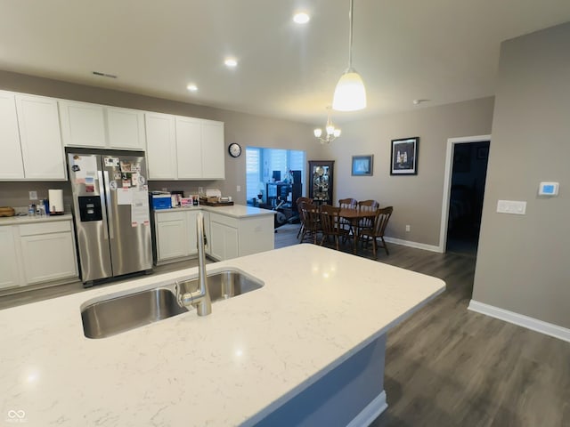 kitchen featuring stainless steel fridge with ice dispenser, hanging light fixtures, dark wood-type flooring, white cabinetry, and a notable chandelier