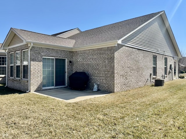 rear view of property featuring brick siding, a yard, and roof with shingles