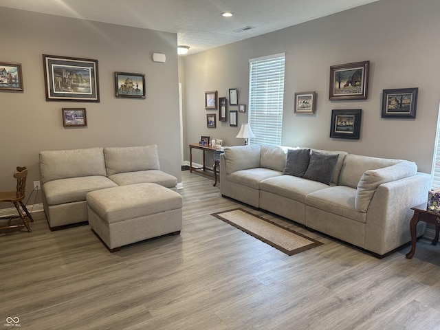 living area featuring recessed lighting, visible vents, baseboards, and light wood finished floors