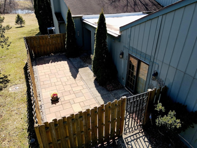 view of home's exterior featuring a patio area, roof with shingles, board and batten siding, and fence