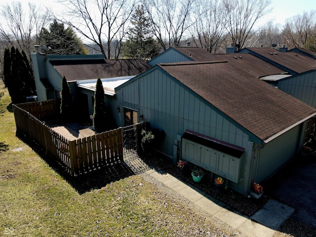 view of home's exterior featuring a lawn, a chimney, and a shingled roof