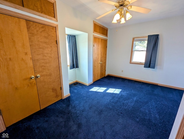 unfurnished bedroom with a ceiling fan, baseboards, and dark colored carpet