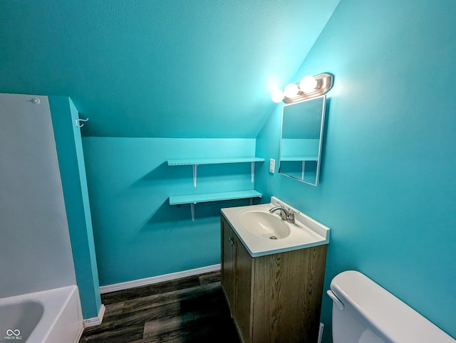 full bath featuring baseboards, toilet, vaulted ceiling, a bathtub, and wood finished floors