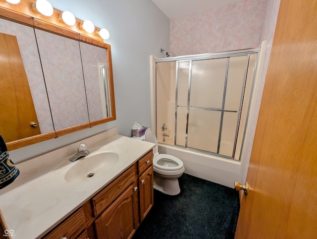 full bath featuring vanity, toilet, and shower / bath combination with glass door