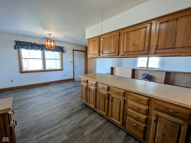 kitchen featuring brown cabinetry, dark wood-style floors, light countertops, and a wealth of natural light