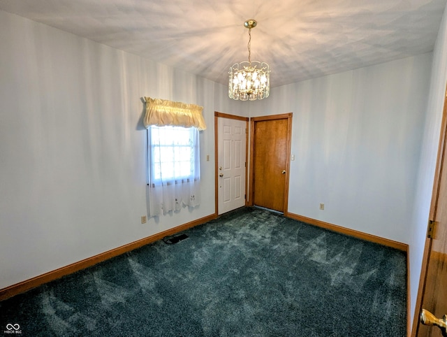 entrance foyer with a notable chandelier, baseboards, and dark carpet