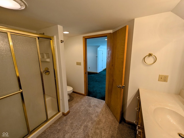 bathroom featuring a shower stall, toilet, vanity, and baseboards