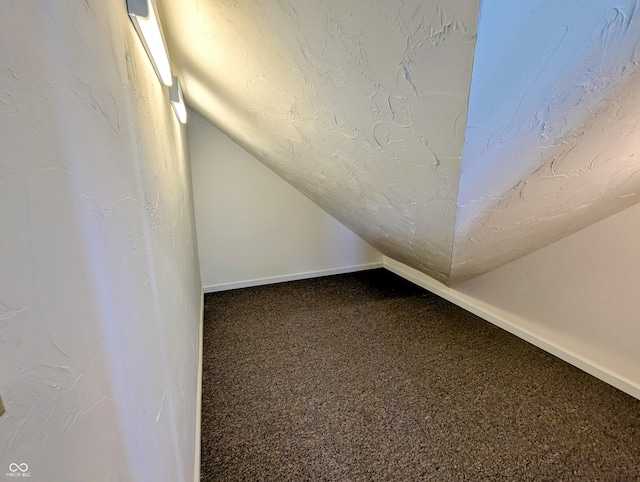 bonus room featuring vaulted ceiling, carpet flooring, baseboards, and a textured ceiling