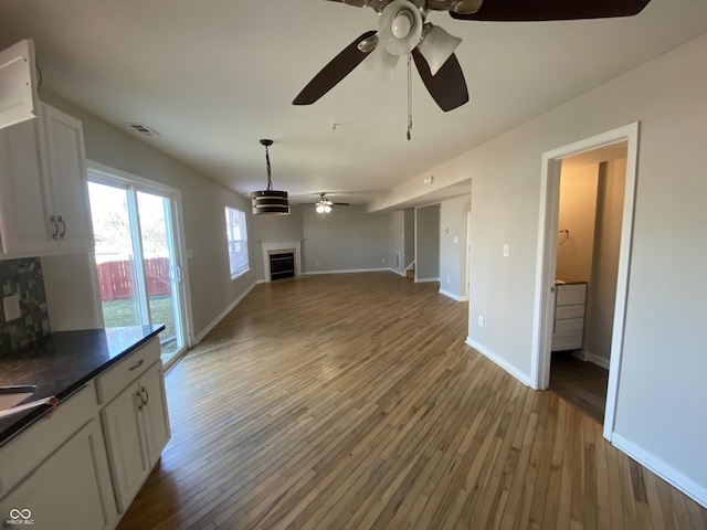 unfurnished living room with visible vents, baseboards, light wood-style flooring, and a fireplace