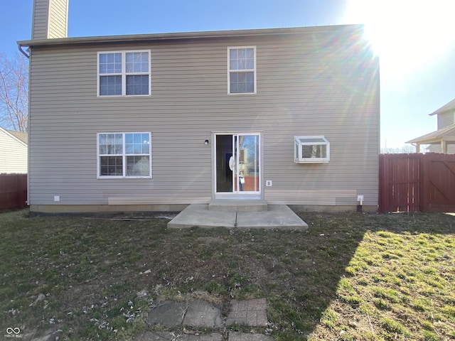 rear view of property featuring a patio, a yard, and fence