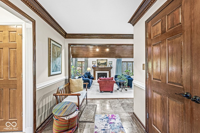 foyer entrance with a healthy amount of sunlight, a fireplace, and crown molding