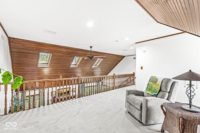 sitting room with a ceiling fan, recessed lighting, a skylight, wood walls, and carpet flooring