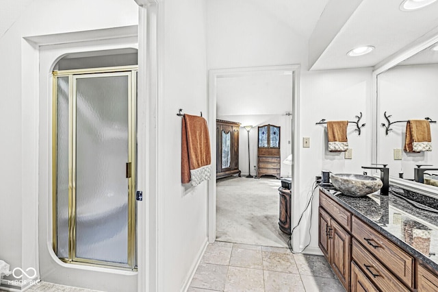 full bathroom featuring tile patterned flooring, a shower stall, vanity, and lofted ceiling