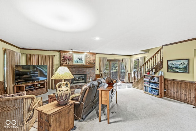 living area with stairs, a wainscoted wall, ornamental molding, and a fireplace