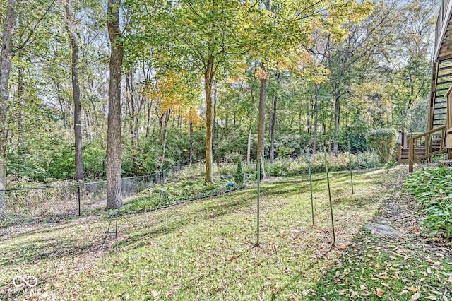 view of yard featuring a forest view and fence