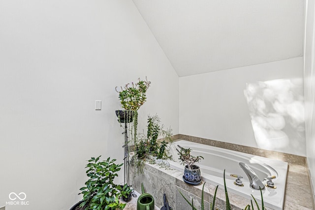 bathroom with vaulted ceiling and a bathing tub