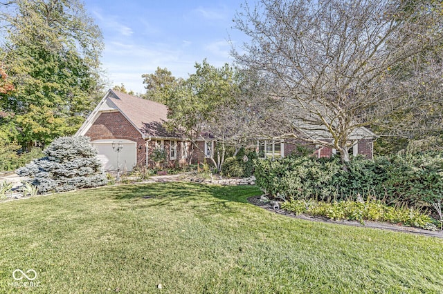 view of property hidden behind natural elements with brick siding, a garage, a front yard, and roof with shingles