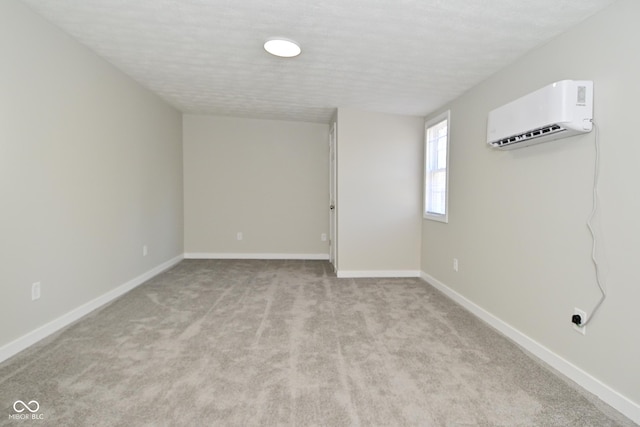 unfurnished room with baseboards, light colored carpet, and a wall mounted AC