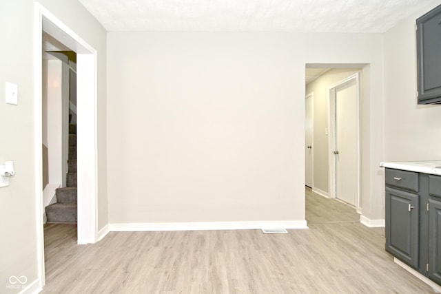 interior space with baseboards, light wood-style flooring, and stairs