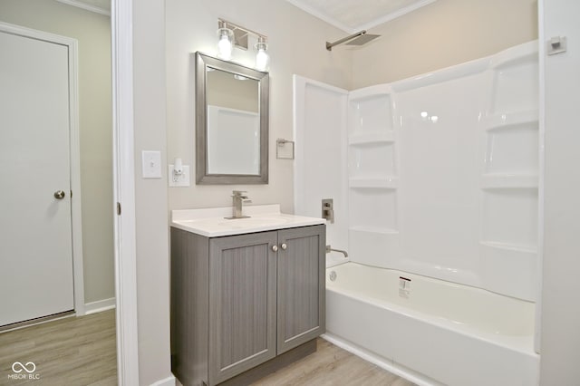 bathroom with vanity, wood finished floors, visible vents, ornamental molding, and shower / washtub combination