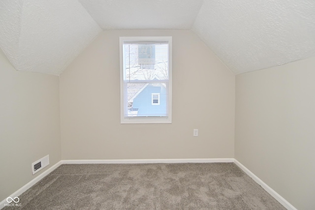 bonus room with baseboards, carpet floors, a textured ceiling, and lofted ceiling