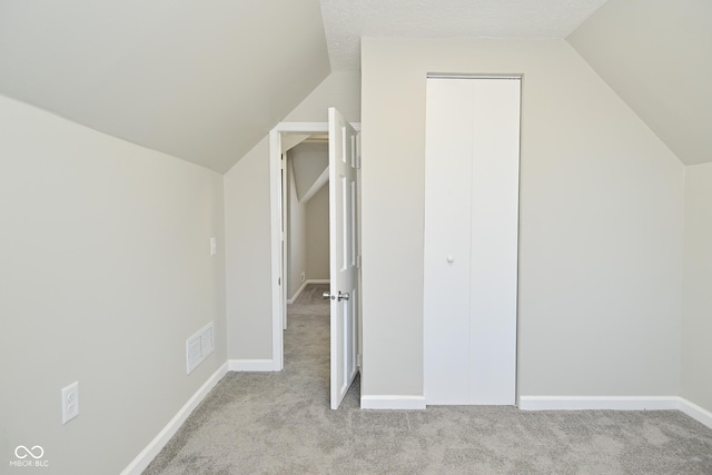 bonus room with light carpet, visible vents, and lofted ceiling