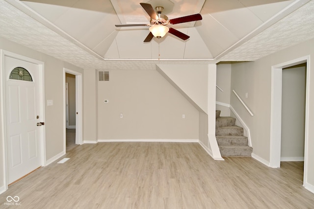 unfurnished living room featuring light wood finished floors, visible vents, baseboards, stairway, and a ceiling fan