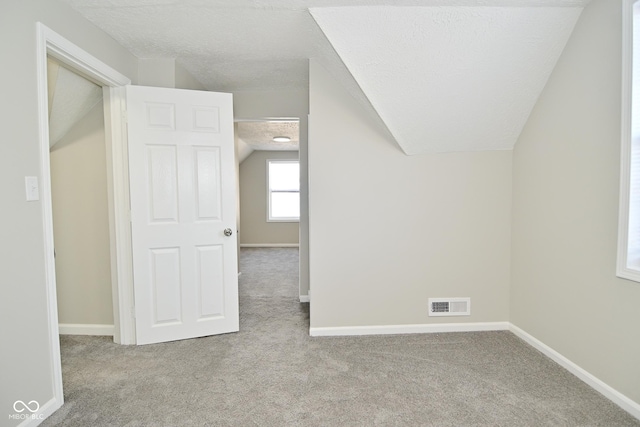 bonus room featuring visible vents, carpet, and vaulted ceiling