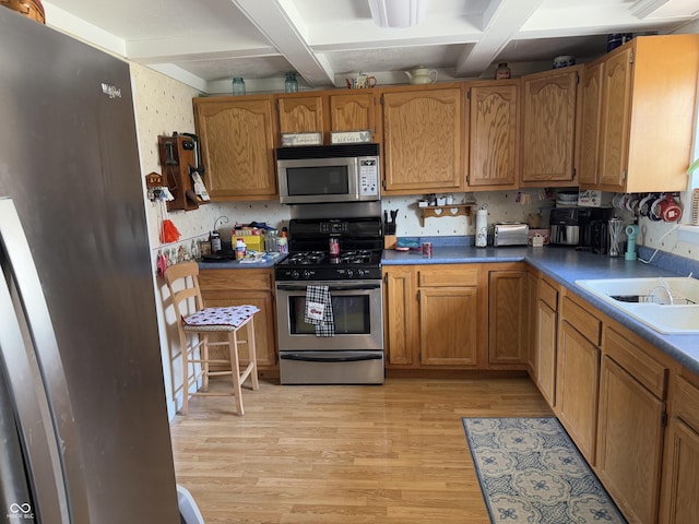 kitchen with beam ceiling, light wood-style floors, appliances with stainless steel finishes, and wallpapered walls