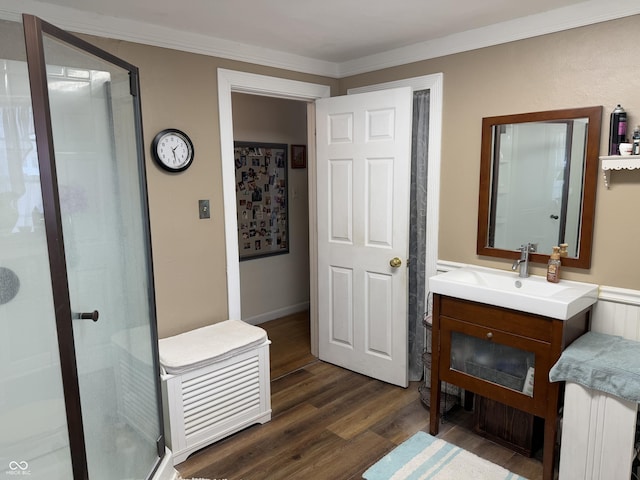 bathroom featuring a stall shower, wood finished floors, vanity, and ornamental molding