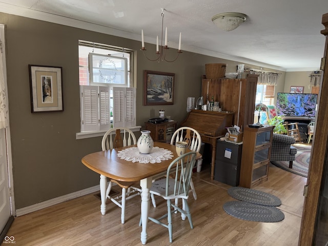 dining area featuring light wood-style flooring, baseboards, and ornamental molding