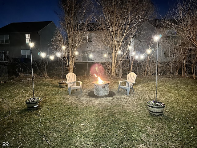 yard at night featuring an outdoor fire pit