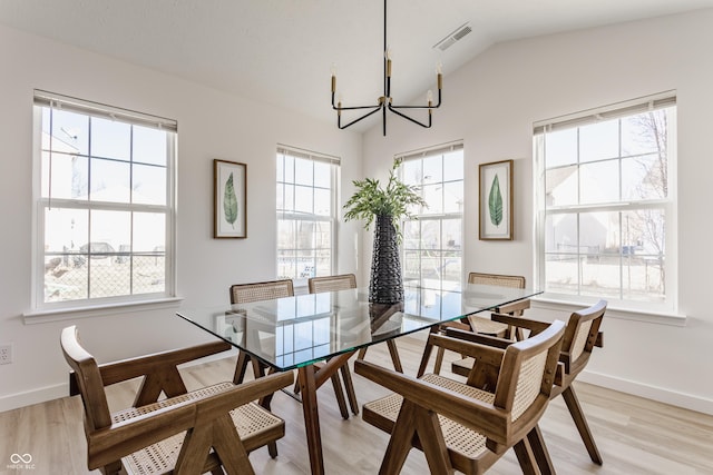 dining space featuring plenty of natural light, light wood-style floors, and an inviting chandelier