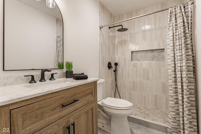 bathroom with tiled shower, toilet, and vanity