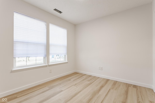 unfurnished room featuring baseboards and wood finished floors