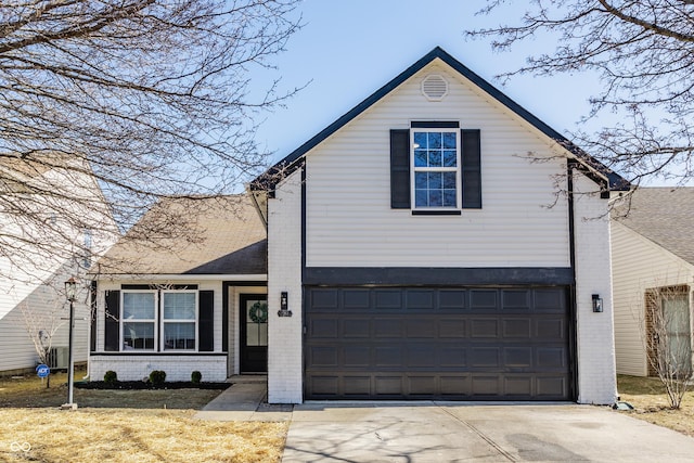 traditional-style home with a garage, brick siding, and driveway