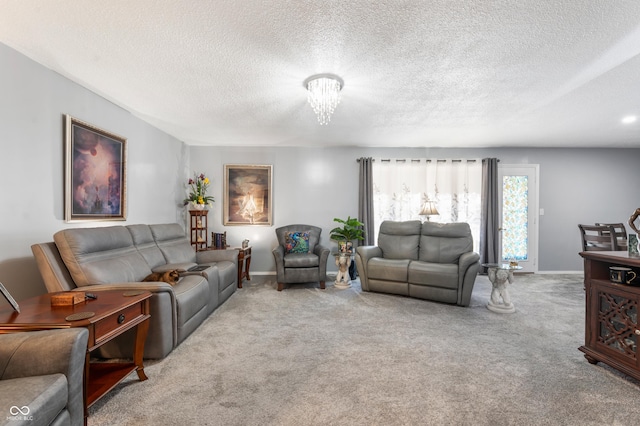 living room featuring baseboards, a textured ceiling, an inviting chandelier, and carpet flooring