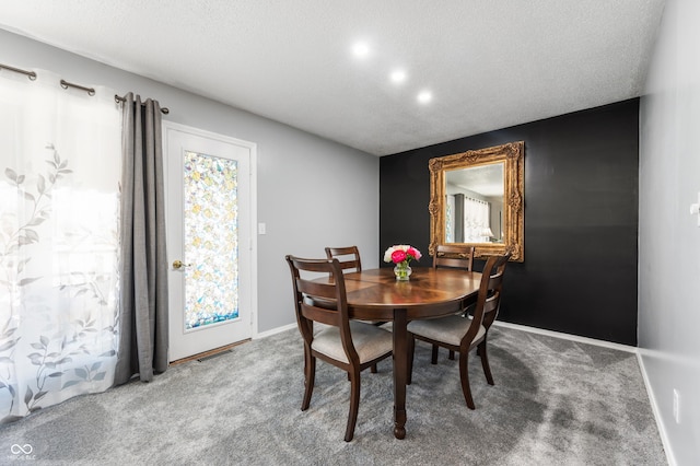 carpeted dining area featuring visible vents, baseboards, and a textured ceiling