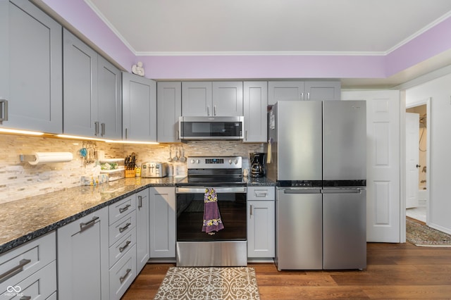 kitchen featuring decorative backsplash, dark wood-style flooring, and appliances with stainless steel finishes