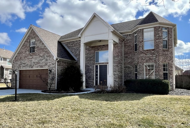 traditional home with a front yard, driveway, a shingled roof, a garage, and brick siding